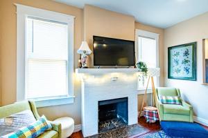 Una sala de estar con chimenea y un televisor de pantalla plana. en Easy A - Flat in heart of N Hyde Park U of Tampa, en Tampa