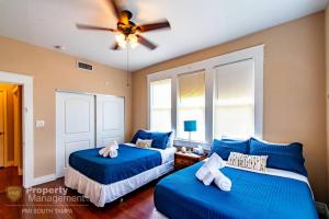 a bedroom with two blue beds and a ceiling fan at Easy A - Flat in heart of N Hyde Park U of Tampa in Tampa