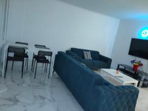 sala de estar con sofá, mesa y sillas en Mon superbe appartement en Argenteuil