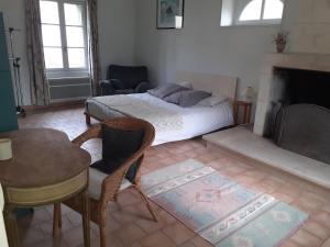 Faverolles-sur-CherにあるGîte A l'ombre de l'Abbayeのベッドルーム1室(ベッド1台、テーブル、椅子付)