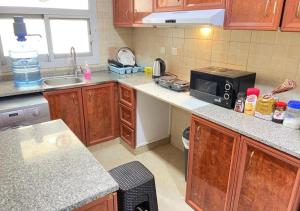 eine Küche mit Spüle und Mikrowelle in der Unterkunft Happy Living Hostel in Dubai