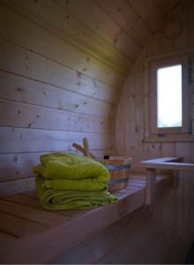 een stapel dekens op een plank in een hut bij Tiny Wellnesslodge Wulp met sauna in Dalerveen