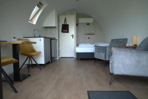 een woonkamer met een keuken en een tafel en stoelen bij Tiny Wellnesslodge Wulp met sauna in Dalerveen