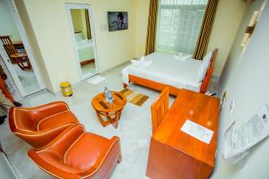 a room with a bed and a table and chairs at Silver Paradise Hotel in Dar es Salaam
