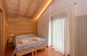 sypialnia z łóżkiem i drewnianym sufitem w obiekcie Bel Sass w mieście Piuro