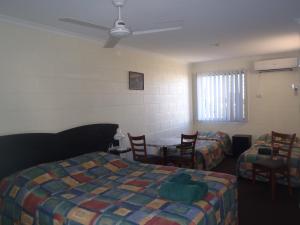 a room with two beds and a table and chairs at Harbour Lodge Motel in Gladstone
