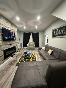 a living room with a couch and a tv at 4 Bedroom Detached House in Liverpool