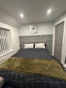 een slaapkamer met een bed met een deken erop bij 4 Bedroom Detached House in Liverpool
