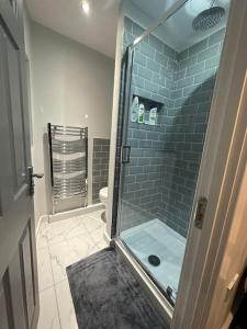 a bathroom with a glass shower with a toilet at 4 Bedroom Detached House in Liverpool