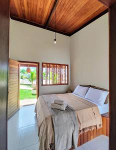 a bedroom with a large bed and a window at Pousada São Miguel Arcanjo in São Miguel do Gostoso
