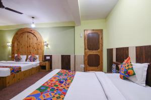a hotel room with two beds and a door at FabHotel River Bank in Vashisht
