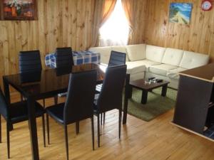 sala de estar con sofá, mesa y sillas en Cabañas Altos del Bosque en Pichilemu