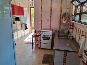 una pequeña cocina con fogones y fregadero en Casa Excepcional em Jaconé com Ar e Piscina en Saquarema