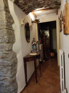 um corredor com uma mesa e uma parede de pedra em La Grotta del Leone em Potenza