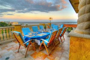 a dining table and chairs on a balcony with the ocean at Ocean Lodge Resort in Saint Simons Island