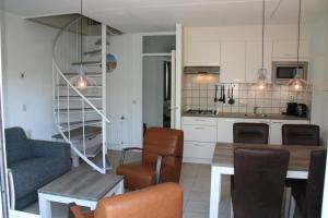 a kitchen and dining room with a table and chairs at Schorrebloem 9* in Nieuwvliet