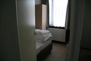 een kleine kamer met een bed en een raam bij Schorrebloem 9* in Nieuwvliet