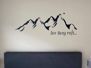 シュルンスにあるAlpenwohnungen Ruprecht Montafonの「北の奥深く」と書かれた看板のある山の壁画