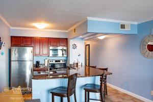 a kitchen with wooden cabinets and a stainless steel refrigerator at Bay Dreamer in Tampa