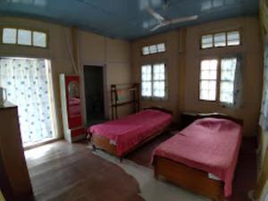 Bhalukpung的住宿－Prashaanti Cottage Bhalukpong，一间带两张床的卧室,位于带窗户的房间内