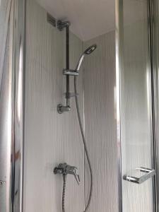 a shower with a shower head in a bathroom at Beautiful Narrowboat Glyndwr in Cambridge