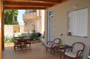 un patio con tavoli, sedie e finestra di Manos House Hersonisos a Hersonissos
