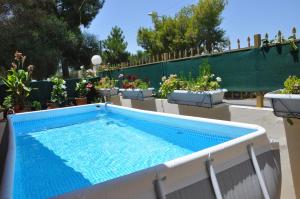 a swimming pool in a garden with potted plants at Manos House Hersonisos in Hersonissos