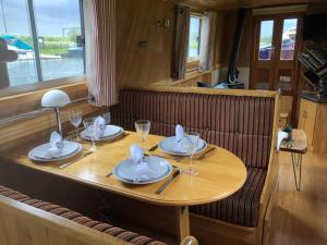 ケンブリッジにあるCambridge Narrowboats - Beautiful New Moon Narrowboatの皿とワイングラスが置かれた木製のテーブル +57枚の写真