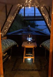 an attic room with a table and a view of a bridge at Beautiful New Moon Narrowboat in Cambridge