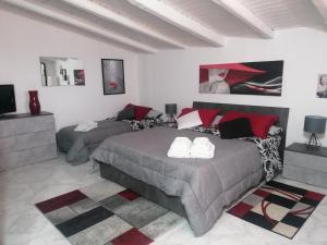 a bedroom with two beds and a television in it at Mamà Apartment in Augusta
