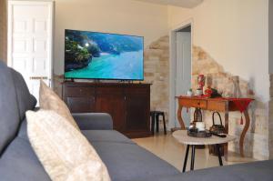 un soggiorno con divano e TV a schermo piatto di Manos House Hersonisos a Hersonissos