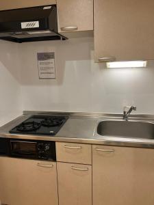 a kitchen with a sink and a stove at Cube Stay 北東京 in Tokyo