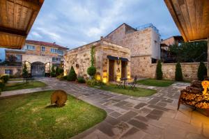 a large stone building with a yard with a patio at Woox Cappadocia in Uçhisar