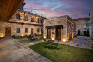 a courtyard with chairs and a table in front of a building at Woox Cappadocia in Uçhisar