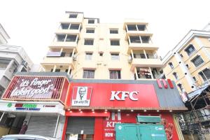 un edificio alto con un cartello kfc davanti di Comfort Place a Salua