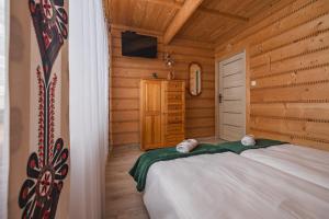1 dormitorio con 1 cama en una cabaña de madera en Wilczkowe Izby, en Leśnica