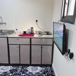 a room with a counter with a desk with a television at استديو البركه-Al Baraka Studio in Umm Lajj