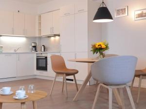 una cucina con tavolo, sedie e vaso di fiori di Ohlerich Speicher App_ 25 a Wismar