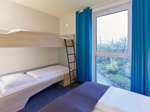 a bedroom with bunk beds and a large window at B&B Hotel Köln-Messe in Cologne