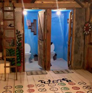 bagno con 2 servizi igienici e pareti blu di The Rabbit Tree Hostel a Gili Meno