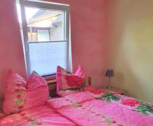 a pink bed with pink pillows and a window at Kölp - Will, Grit und Martin in Kolpinsee