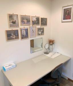 un ufficio con una scrivania e delle foto appese al muro di Guesthouse Hope a Hashima