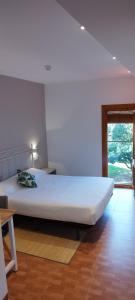 Cette chambre comprend un grand lit et une fenêtre. dans l'établissement B&B La Atalaya, à Olite