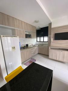 a kitchen with a refrigerator and a table in it at Golden Point Apartamento em Recife in Recife