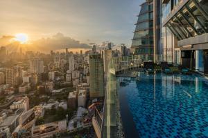 ein Pool auf einem Gebäude mit einer Stadt in der Unterkunft The Continent Hotel Sukhumvit - Asok BTS Bangkok by Compass Hospitality in Bangkok