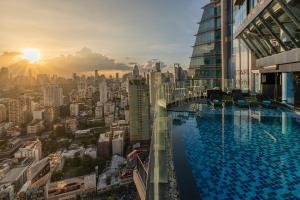バンコクにあるThe Continent Hotel Sukhumvit - Asok BTS Bangkokの街並みが見える建物の屋上にあるプール