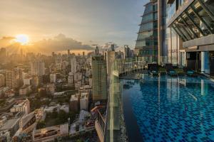 a swimming pool on top of a building with a city at The Continent Hotel Sukhumvit - Asok BTS Bangkok by Compass Hospitality in Bangkok