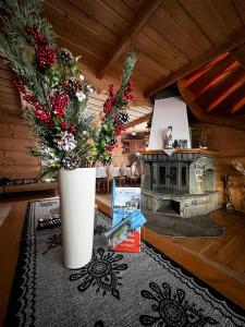 a vase with flowers in a room with a fireplace at Szałas u Eweliny in Kościelisko