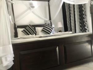 un letto con cuscini bianchi e neri e uno specchio di skyresort a Tangalle