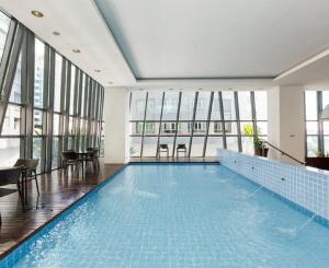 a large swimming pool in a building with windows at Ascott Sentral Kuala Lumpur in Kuala Lumpur